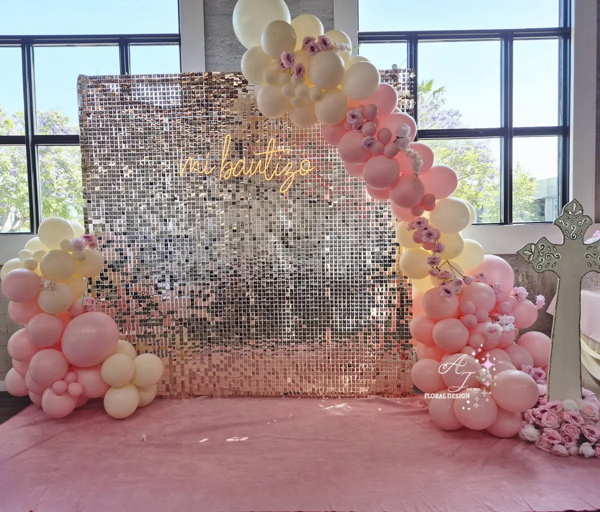 Pared dorada de lentejuelas con arco de globos montada por AJ Floral Design